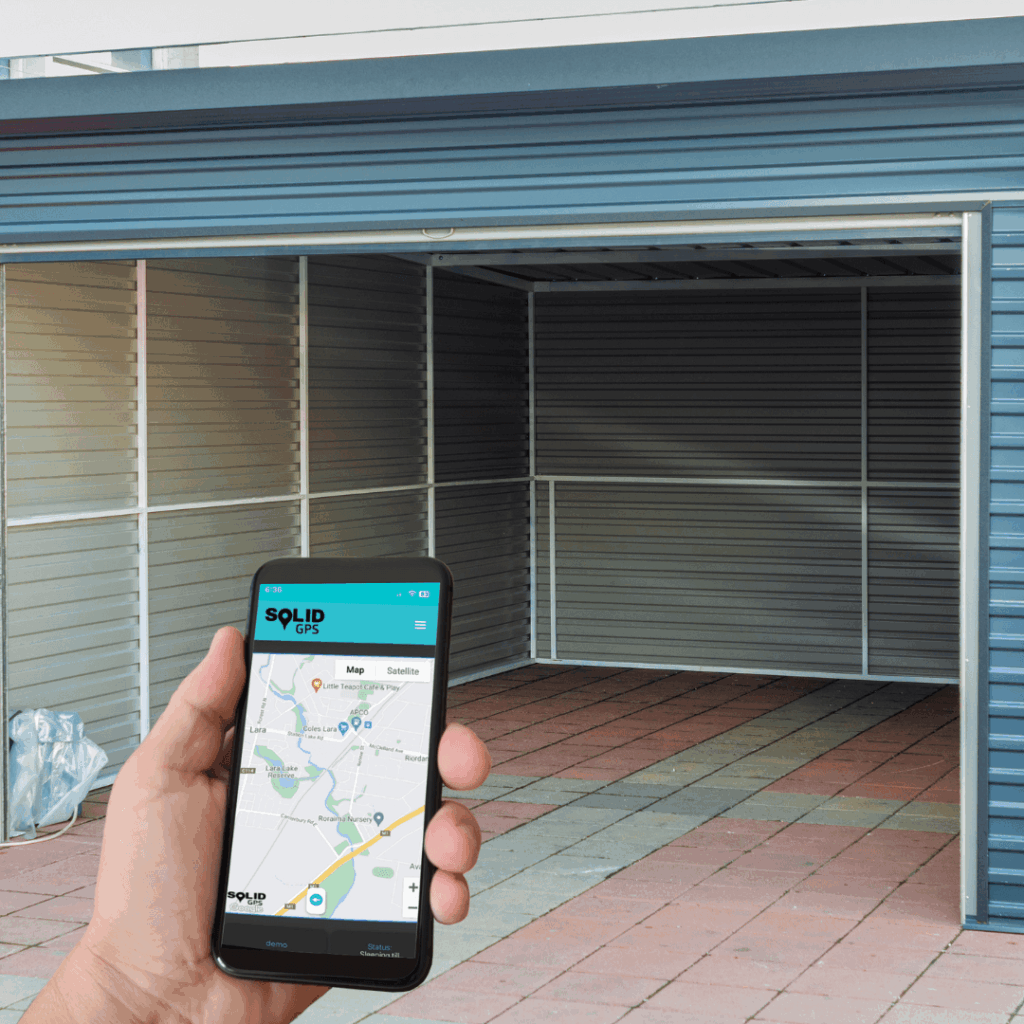 Hand holding a phone with the Solid GPS app tracking a location in front of an empty garage